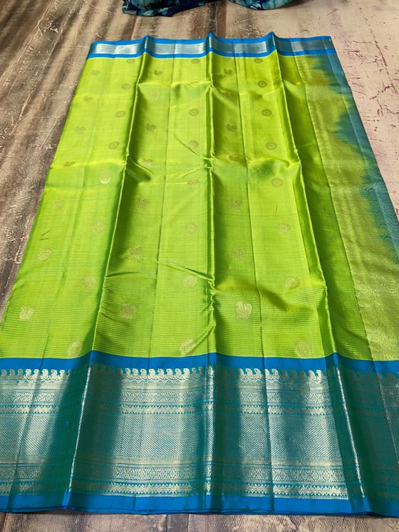 Parrot green silk saree with gold buttis and a peacock blue zari border