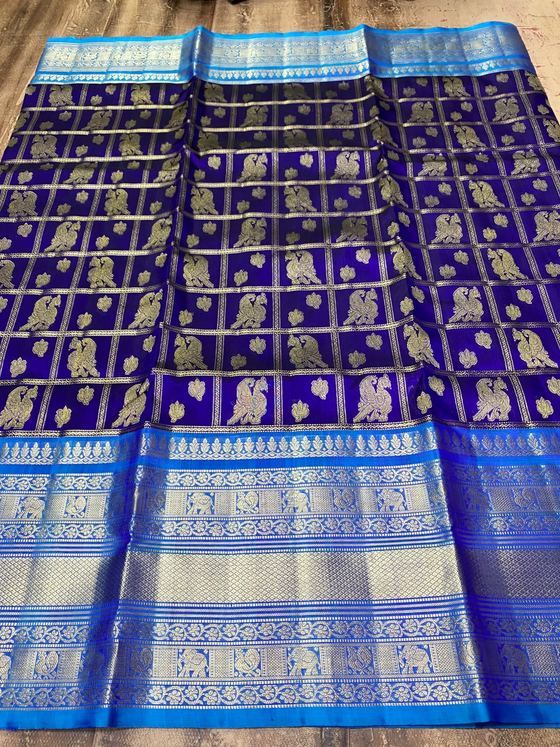 Royal blue silk saree with gold parrot motifs in checks and a sky-blue zari border